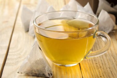 fincan çay ve çay poşeti piramit. yakın çekim. ahşap bir masaya. çay yapmak için