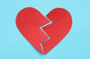 Parlak mavi bir arka plan üzerinde kırmızı kalp kırık. kırık aşk