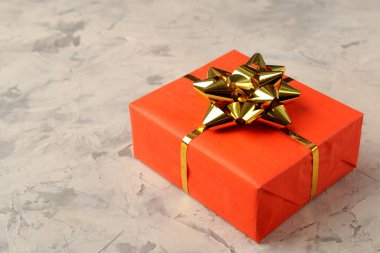 Red gift box close up on a light concrete background. Valentine's Day. space for text