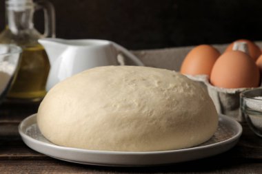 Fırın malzemeleri. pişirme araçları. hamur tatlı ve tereyağı, yumurta, şeker, kahverengi ahşap zemin üzerinde süt.