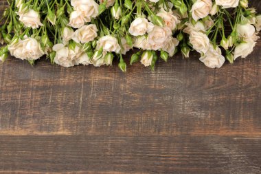 Güzel mini gül kahverengi ahşap bir masa üzerinde çerçeve. güzel çiçekler. tatil. üstten görünüm