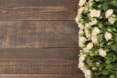 Güzel mini gül kahverengi ahşap bir masa üzerinde çerçeve. güzel çiçekler. tatil. üstten görünüm