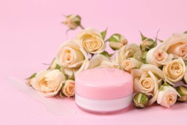 Kozmetik için yüz ve vücut narin pembe bir arka plan üzerinde taze gül pembe şişelerde. krem ve losyon. Spa.