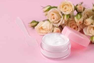 Kozmetik için yüz ve vücut narin pembe bir arka plan üzerinde taze gül pembe şişelerde. krem ve losyon. Spa.