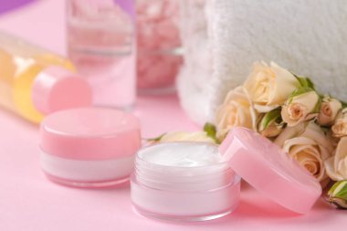 Kozmetik için yüz ve vücut narin pembe bir arka plan üzerinde taze gül pembe şişelerde. krem ve losyon. Spa.