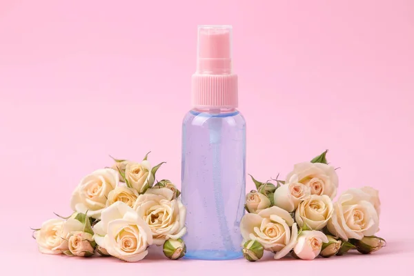 cosmetics for face and body in pink bottles with fresh roses on a delicate pink background. cream and lotion. spa.