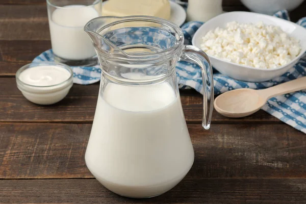 milk products. milk, sour cream, cheese, butter and cottage cheese on a brown wooden table