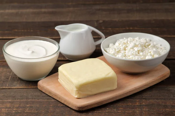 乳製品 サワー クリーム チーズ バター 茶色の木製のテーブルにカッテージ チーズ — ストック写真