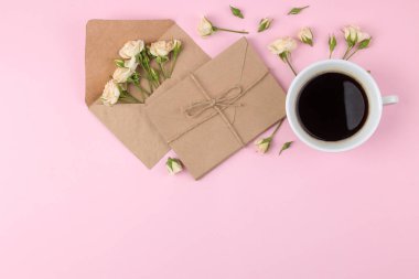 Bir fincan kahve ve parlak pembe bir arka plan üzerinde zarf güzel mini gül. tatil. Sevgililer günü. Kadınlar günü. yukarıdan görüntüleyin. metin için yer