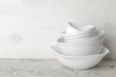 Bulaşık yığını. hafif bir beton zemin üzerine sofra. tablo hizmet için yemekler. bir yığın halinde beyaz kase. metin için yer