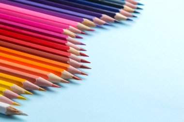 Parlak mavi bir arka plan üzerinde renkli kalemler ile kompozisyon. yakın çekim. metin için yer