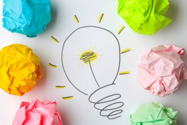 Kavram yaratıcı bir fikir. yaratıcı bir fikir kavramı. Buruşuk Kağıt topları ve boyalı ampul parlak arka plan üzerinde. metafor, ilham.