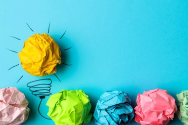 Kavram yaratıcı bir fikir. yaratıcı bir fikir kavramı. Buruşuk Kağıt topları ve boyalı ampul parlak arka plan üzerinde. metafor, ilham.