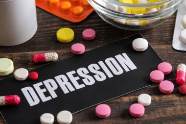 Depresyon kavramı. Kağıt ve ahşap bir kahverengi masa hapları üzerinde yazıt depresyon.