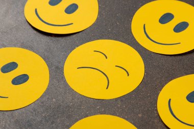 Depresyon kavramı. Psikolojik hastalık. karanlık bir arka plan üzerinde komik suratlar arasında üzgün smiley.