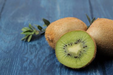 Lezzetli olgun birçok kivi ve kivi mavi ahşap bir masa bir kesim içinde. yakın çekim.