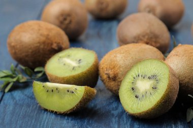 Lezzetli olgun birçok kivi ve kivi mavi ahşap bir masa bir kesim içinde. yakın çekim.