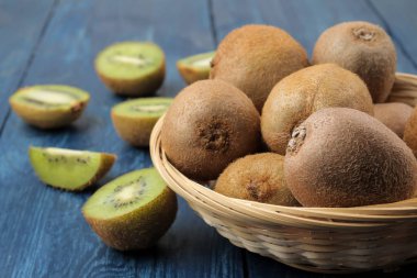 Lezzetli olgun birçok kivi ve kivi mavi ahşap bir masa bir kesim içinde.
