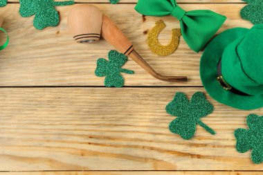 St.Patrick'ın gün. kutlama. Yeşil cüce şapkası, papyon, boru ve hediye kutusu doğal ahşap arka plan üzerinde sigara. Yukarıdan görüntüleyin. metin için yer