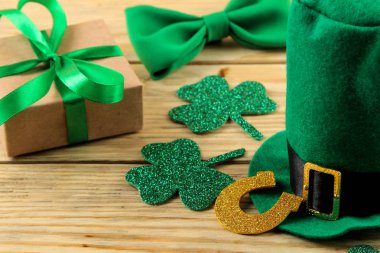 St.Patrick'ın gün. kutlama. Yeşil cin şapka, at nalı ve yonca bir doğal ahşap arka plan üzerinde bırakır. yakın çekim