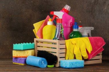 Temizleyiciler ve kahverengi bir arka plan üzerine bir kutu içinde deterjanlar ile şişe. temizlik. temizlik ürünleri.