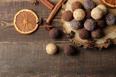 çeşitli çikolatalar. şeker topları çikolata kahverengi ahşap bir masa üzerinde farklı türde. tarçın ve kakao. Üstten Görünüm