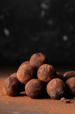 çeşitli çikolatalar. şeker topları çikolata koyu arka plan üzerinde farklı türde. Kakao ve kahve fasulye. boş alan