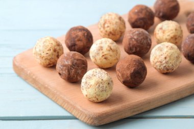 çeşitli çikolatalar. Şeker topları çikolata Mavi ahşap bir masa üzerinde bir ahşap tahta üzerinde farklı türde.