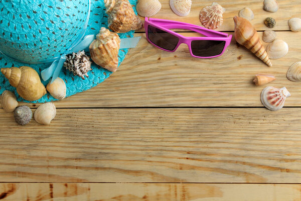 Travel concept Hat, glasses and shells on a natural wooden table. relaxation. holidays. top view. free space