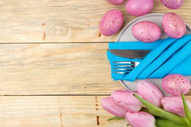 Paskalya. Paskalya sofra. Pembe Paskalya yumurta ve doğal ahşap bir masa üzerinde çiçekler. Mutlu paskalyalar. tatil. Üstten Görünüm