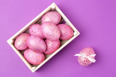 Paskalya. Pembe yumurta trendy Lila zemin üzerine bir kutu içinde. Mutlu paskalyalar. tatil. Üstten Görünüm