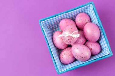 Paskalya. Paskalya yumurtaları trendy leylak arka plan üzerinde bir sepette pembe. Mutlu paskalyalar. tatil. Üstten Görünüm