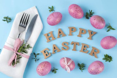 Paskalya. Pembe Paskalya yumurtaları ve trendy bir mavi zemin üzerine çatal bıçakla. Paskalya sofra. Mutlu paskalyalar. tatil. Üstten Görünüm.