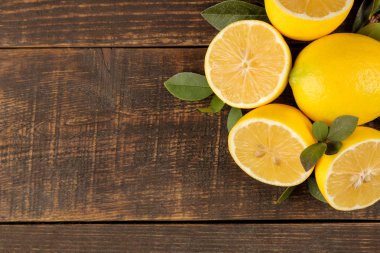 Narenciye meyve. Taze limon yaprakları üzerinde kahverengi ahşap bir masa ile. Yukarıdan görüntüleyin. boş alan
