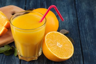 Narenciye meyve. Taze turuncu yaprak ve mavi ahşap bir masa suyu ile.