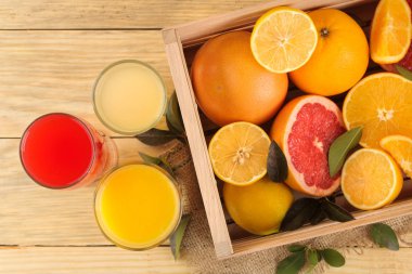 Narenciye meyve. çeşitli narenciye yaprakları limon, portakal, greyfurt bir kutu ve doğal ahşap bir masa üzerinde suları ile. Üstten Görünüm