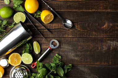 Mojito bir cam bardak limon, nane ve limon ve Aksesuar ahşap bir kahverengi masa üzerinde bar kokteyl. pişirme mojito. Üstten Görünüm. Ücretsiz yer