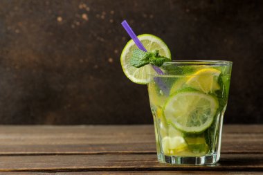 Mojito kokteyl limon, nane ve limon ahşap bir kahverengi masa üzerinde cam bardakta