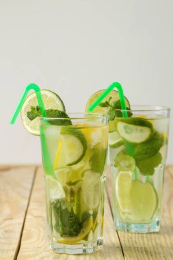 Kokteyl limon, nane ve limon ve doğal ahşap bir masa üzerinde bir cam bardak Mojito. bir mojito yapmak.