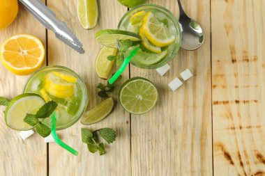Mojito cam cam aksesuarları doğal ahşap bir masa üzerinde bar ve limon, nane ve limon ile kokteyl. bir mojito yapmak. Üstten Görünüm