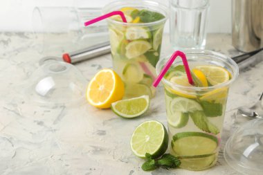 Kokteyl bar aksesuarları üzerinde beton masa lambası ve limon, nane ve limon ile bir plastik bardak Mojito. bir mojito yapmak.