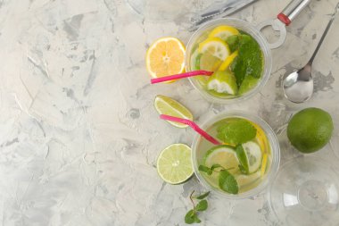 Mojito kokteyl limon, nane ve limon beton masa lambası üzerinde plastik bardakta. bir mojito yapmak. Üstten Görünüm.