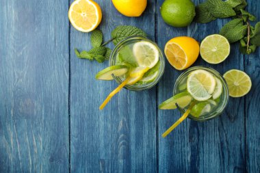 Kokteyl limon, nane ve limon mavi ahşap bir masa üzerinde bir cam bardak Mojito. bir mojito yapmak. Üstten Görünüm