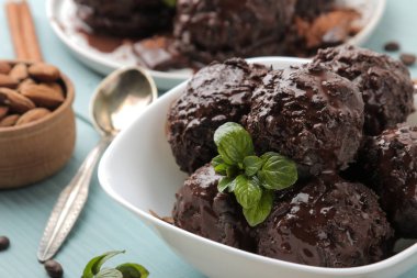 Çikolatalı dondurma ile sıvı çikolata ve tarçın çubuğu, kahve çekirdekleri ile mavi ahşap zemin badem.