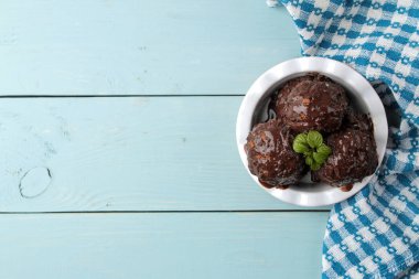 Sıvı bir mavi ahşap arka plan üzerinde çikolata ile Çikolatalı dondurma. Üstten Görünüm
