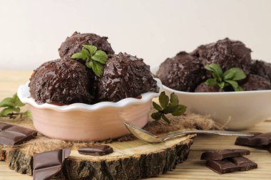 Sıvı çikolata ile Çikolatalı dondurma ve doğal ahşap zemin üzerine nane yaprağı.