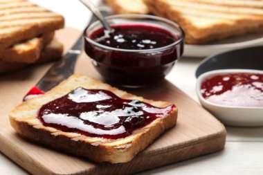 tost reçelli. Beyaz ahşap bir masa üzerinde kırmızı reçel ile kızarmış gevrek tost. Kahvaltı. yakın çekim