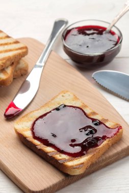 tost reçelli. Beyaz ahşap bir masa üzerinde kırmızı reçel ile kızarmış gevrek tost. Kahvaltı. yakın çekim