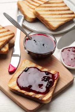 tost reçelli. Beyaz ahşap bir masa üzerinde kırmızı reçel ile kızarmış gevrek tost. Kahvaltı. yakın çekim