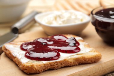 tost reçelli. doğal ahşap bir masa üzerinde kırmızı reçel ile kızarmış gevrek ekmek. Kahvaltı. yakın çekim